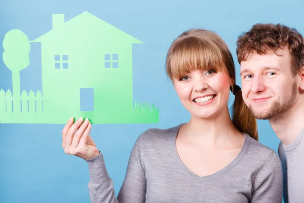 Couple holding house cutout. Stock Picture
