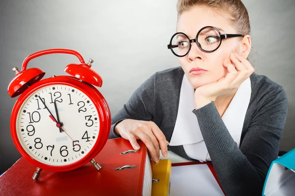 Geschäftsfrau im Amt mit großer roter Uhr. — Stockfoto