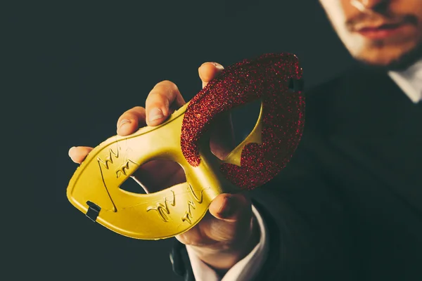 Manlig hand håller carnival mask närbild — Stockfoto