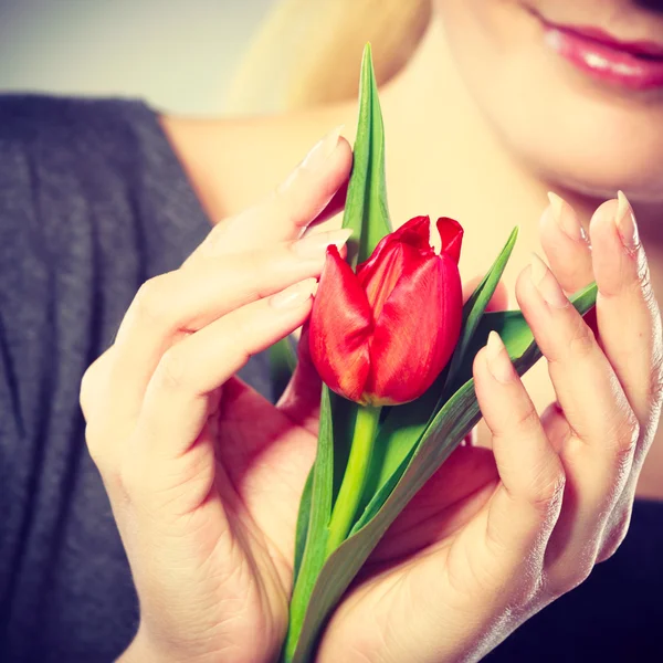 Lächelnde Frau umarmt Blume. — Stockfoto