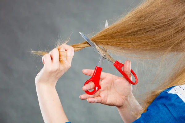 Mujer rubia cortándose el pelo . — Foto de Stock