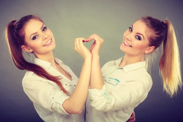 Two girls with heart love gesture — Stock Photo, Image