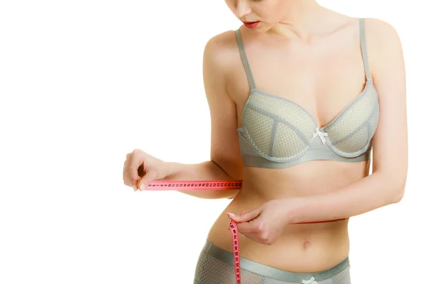 Woman in lingerie measuring her waist with measure tape. — Stock Photo, Image