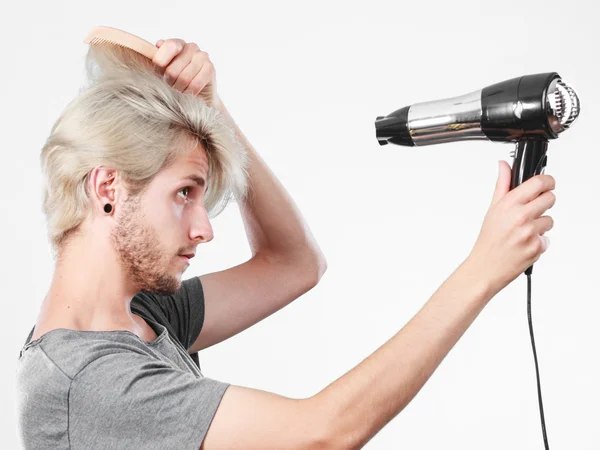 Giovane uomo asciugatura capelli con asciugacapelli — Foto Stock