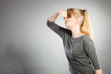 Sarışın kız holding burun.