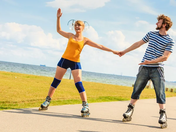 Tineri cuplu pe role skates echitatie în aer liber — Fotografie, imagine de stoc