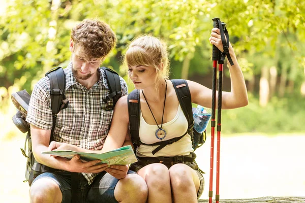 Excursionistas mochileros pareja lectura mapa en viaje . — Foto de Stock