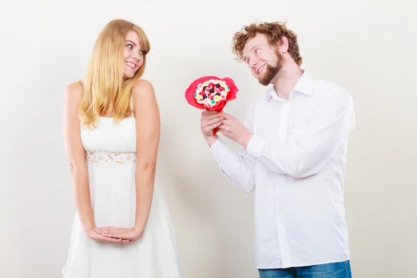 Glückliches Paar mit Süßigkeiten Strauß Blumen. Liebe. — Stockfoto