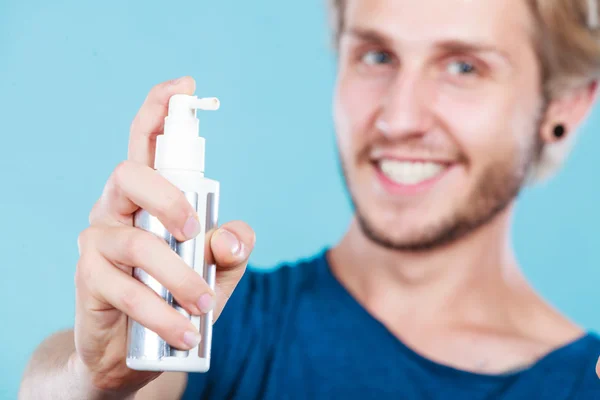 Man op zijn haar spray cosmetische toe te passen — Stockfoto