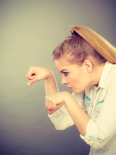 Angry mad woman clenching fist punching on gray. Stock Photo