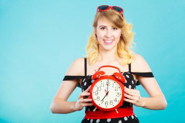 Mavi çalar saat ile gülümseyen kız.