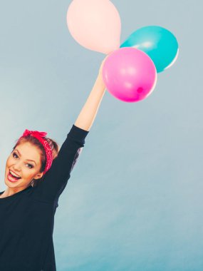 Balonlarla eğleniyor gülümseyen çılgın kız.