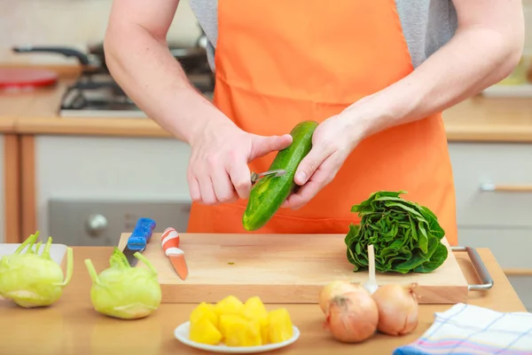 Hombre preparando verduras ensalada pelado pepino — Foto de Stock