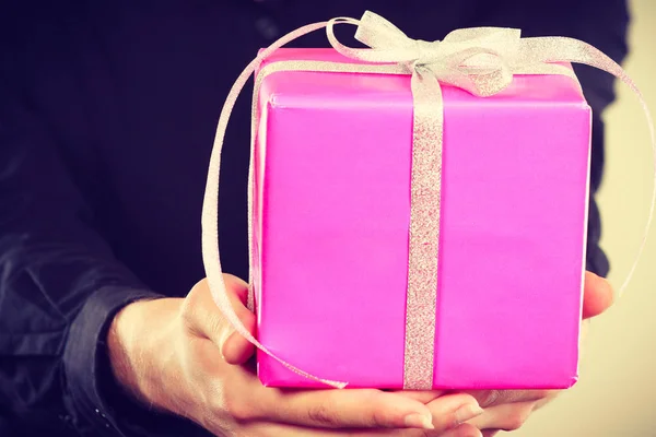pink gift box in male hands