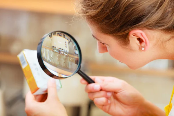 Mujer inspeccionando mantequilla con lupa . — Foto de Stock