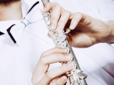 Eller genç adamın flüt çalmaya