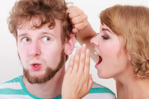 Woman telling an astonished man some secrets — Stock Photo, Image