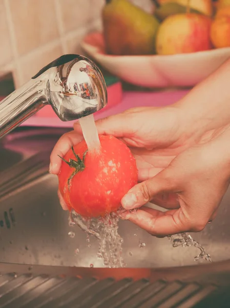 Mujer lavando verduras frescas en la cocina —  Fotos de Stock