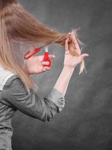 Mujer rubia cortándose el pelo . — Foto de Stock