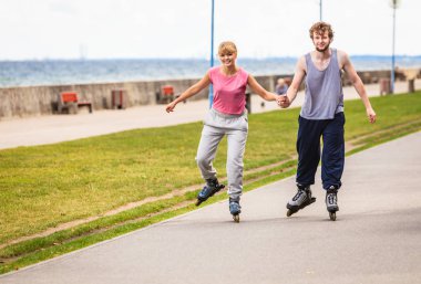 Aktif genç insanlar arkadaş paten açık.