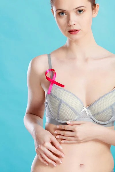 Жінка в бюстгальтері з стрічкою обізнаності про рак молочної залози — стокове фото