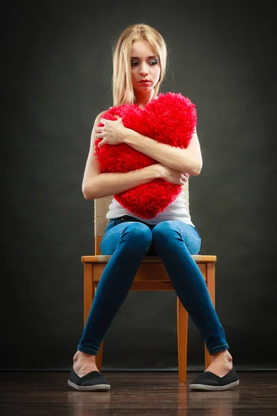 Triste mulher infeliz segurando travesseiro coração vermelho — Fotografia de Stock