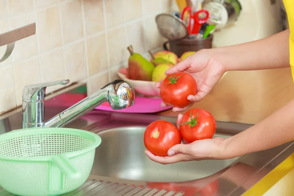 Mujer lavando verduras frescas en la cocina —  Fotos de Stock