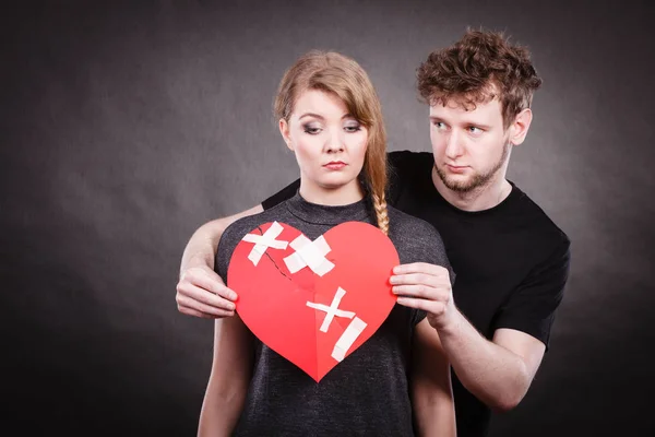 Triste pareja sostiene corazón roto . — Foto de Stock