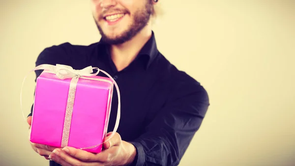 Man holding present pink gift box in hand — Stock Photo, Image