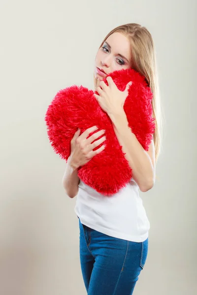 Triste mujer infeliz sosteniendo almohada roja del corazón — Foto de Stock