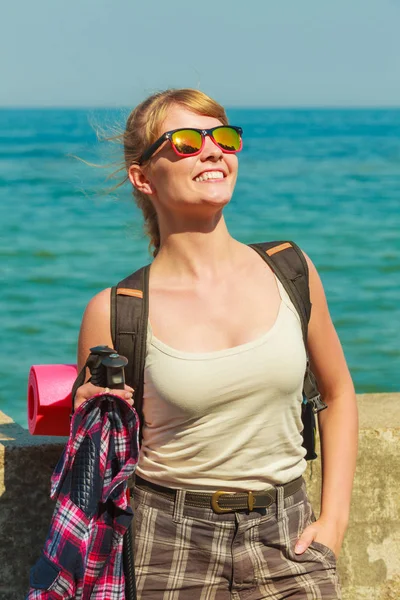 Mujer joven con mochila senderismo en la costa del mar — Foto de Stock