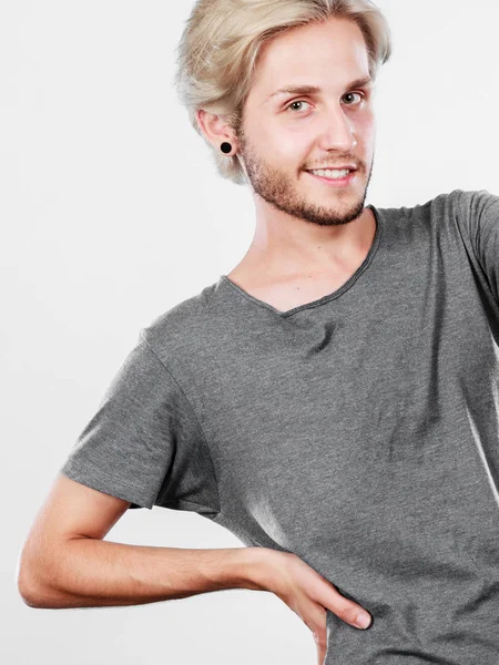 Glücklich lächelnder blonder Mann im grauen T-Shirt — Stockfoto