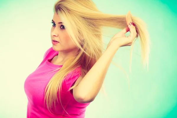 Blondine streicht sich ihre langen Haare — Stockfoto