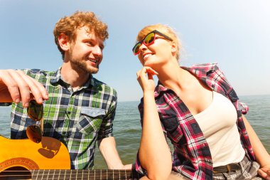 Genç kadın için gitar çalmak hipster adam.