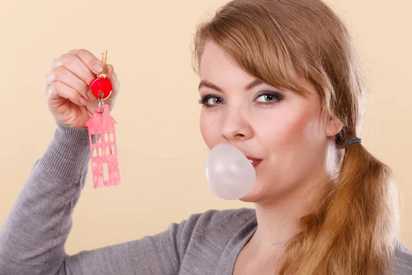 Rolig kvinna håller hus nycklar äta tuggummi — Stockfoto