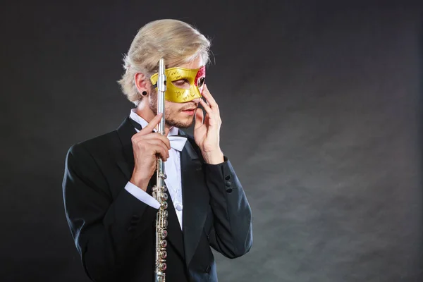 Man in carnival mask playing flute — Stock Photo, Image