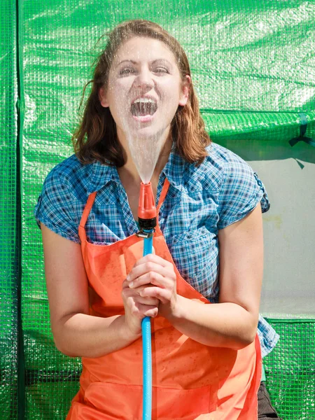 Woman watering the garden with hose — Stock Photo, Image