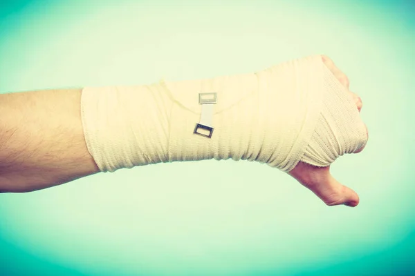 Male bandaged hand with thumb down sign. — Stock Photo, Image