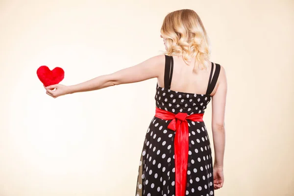 Vrouw in gestippelde jurk rood hart houden — Stockfoto