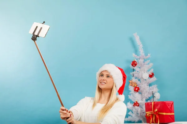 Woman in santa hat taking selfie — Stock Photo, Image