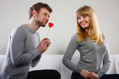 Man giving heart to his girl. clipart