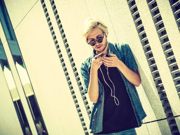Hipster homem ouvindo música através de fones de ouvido — Fotografia de Stock