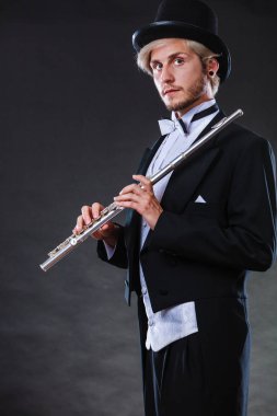 Zarif giyimli müzisyen flüt tutan