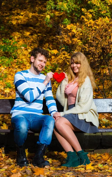 Pareja romántica sentarse en el banco en el parque otoñal — Foto de Stock