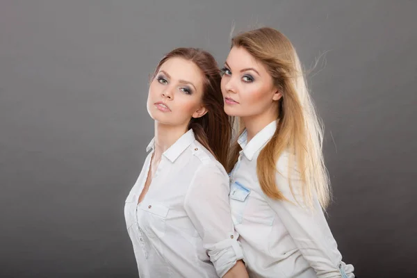 Two beautiful women, blonde and brunette posing — Stock Photo, Image