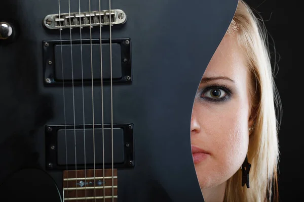 Mulher loira segurando guitarra elétrica, fundo preto — Fotografia de Stock