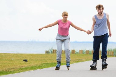 Genç bir çift paten yaparken elele