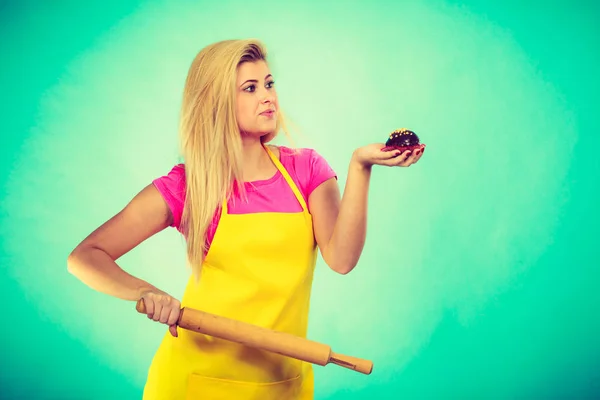 Woman holding rolling pin and chocolate cupcake — Stock Photo, Image