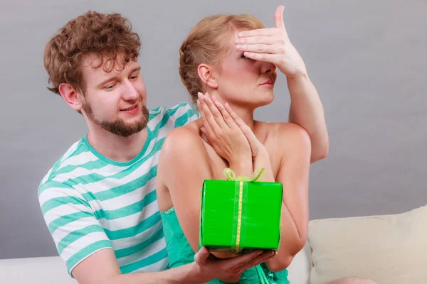 Young man giving woman gift box — Stock Photo, Image