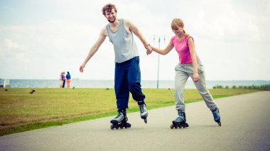 Genç bir çift paten yaparken elele